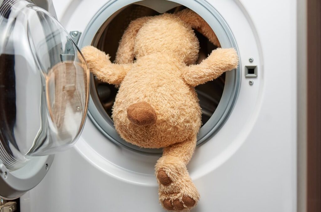 洗濯機に入ろうとするウサギのぬいぐるみ